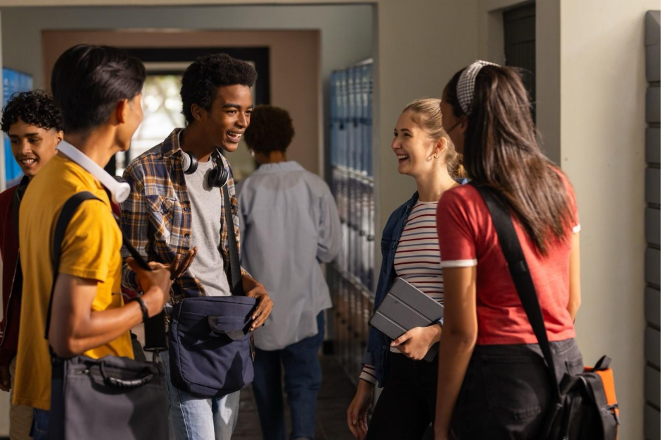 A group of people talking in a hallway

Description automatically generated